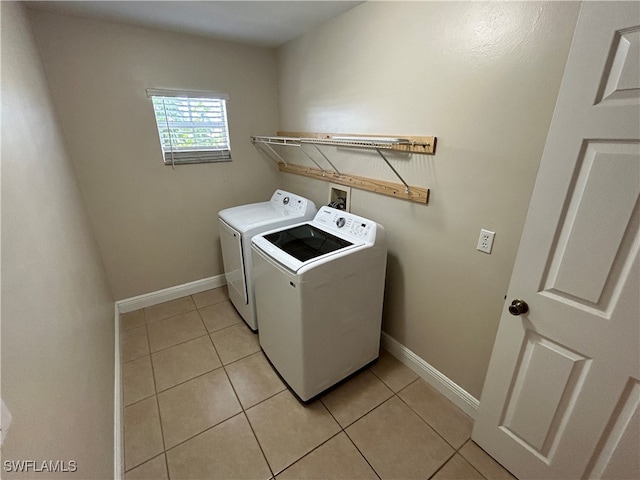 washroom featuring washer and clothes dryer and light tile patterned floors