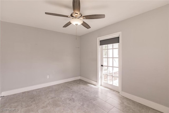 unfurnished room featuring ceiling fan and baseboards