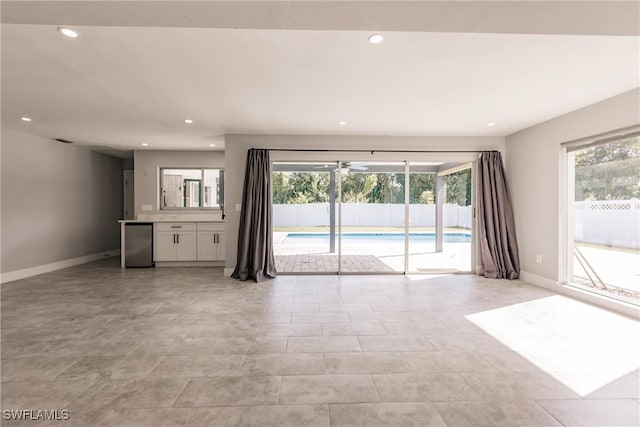 unfurnished living room with baseboards and recessed lighting