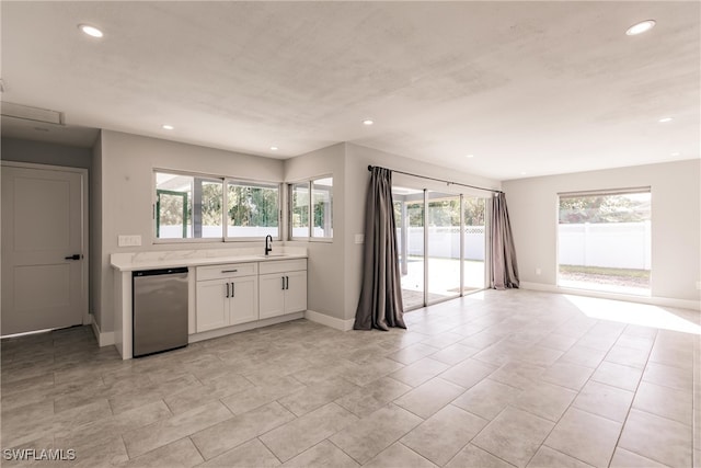 kitchen with recessed lighting, white cabinets, open floor plan, light countertops, and stainless steel dishwasher