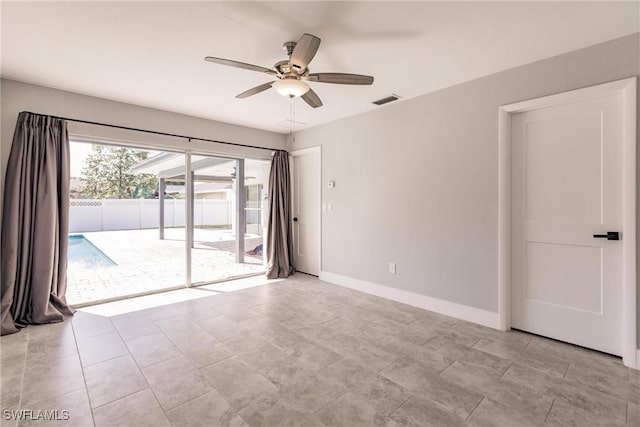 empty room featuring a ceiling fan, visible vents, and baseboards