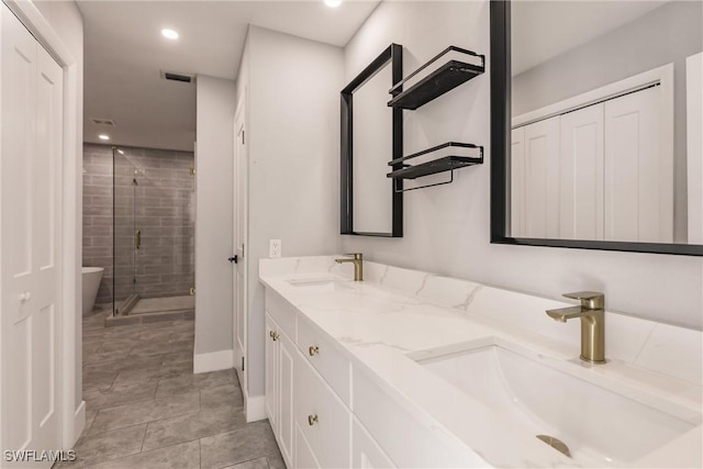 full bath with double vanity, a shower stall, visible vents, and a sink