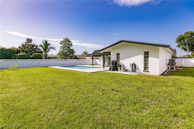 back of house featuring a patio, a fenced backyard, a lawn, a fenced in pool, and stucco siding