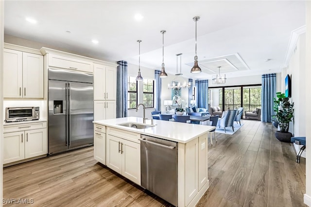 kitchen with plenty of natural light, decorative light fixtures, sink, and appliances with stainless steel finishes