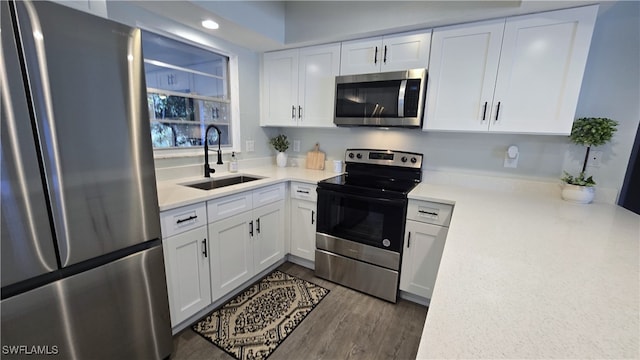 kitchen featuring dark hardwood / wood-style floors, sink, white cabinetry, and stainless steel appliances