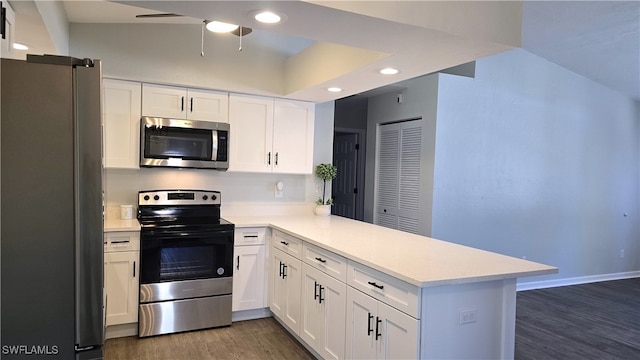 kitchen with kitchen peninsula, white cabinets, dark hardwood / wood-style floors, and appliances with stainless steel finishes