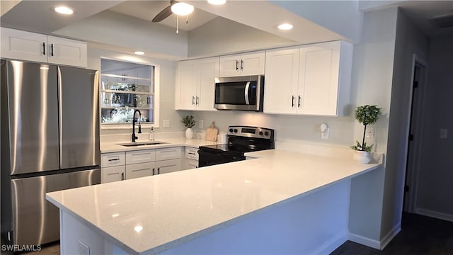 kitchen featuring kitchen peninsula, sink, ceiling fan, appliances with stainless steel finishes, and white cabinetry