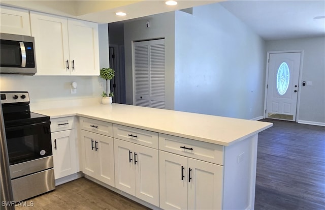 kitchen with kitchen peninsula, white cabinetry, and appliances with stainless steel finishes