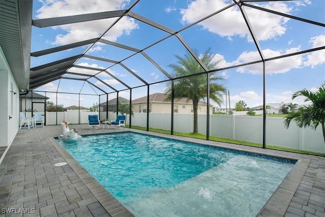 view of swimming pool featuring glass enclosure, a patio area, and pool water feature