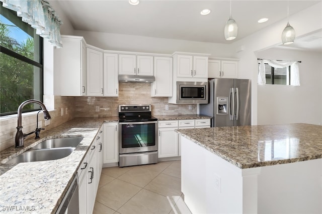 kitchen with a wealth of natural light, sink, appliances with stainless steel finishes, and a kitchen island