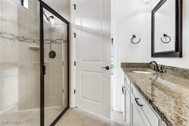 bathroom featuring vanity, tile patterned floors, and a shower with door