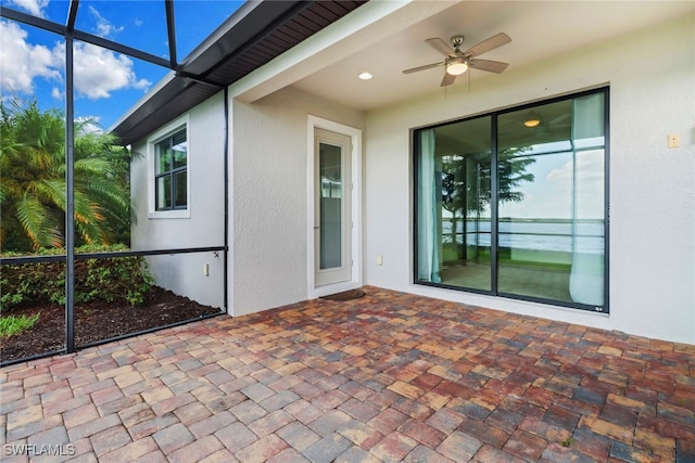 view of patio featuring glass enclosure and ceiling fan