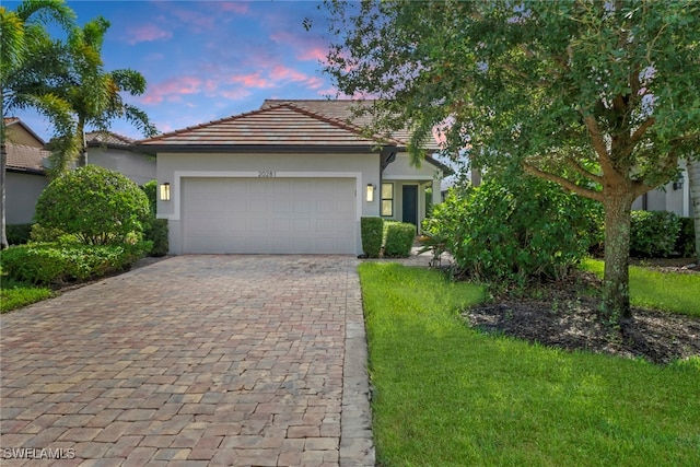 view of front of house featuring a garage and a lawn