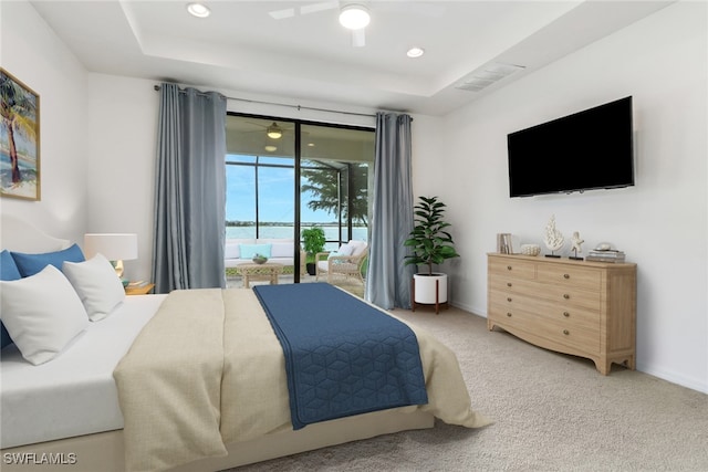 carpeted bedroom with ceiling fan, access to outside, and a tray ceiling