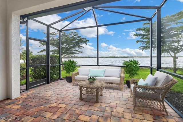 sunroom featuring a water view