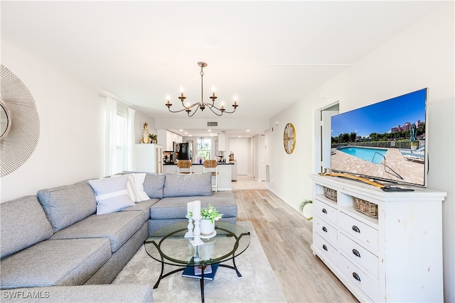 living area featuring a chandelier, visible vents, and light wood finished floors