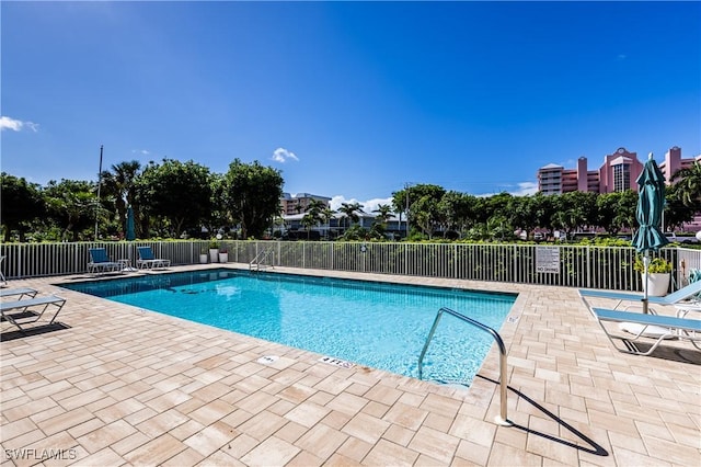 community pool featuring fence and a patio