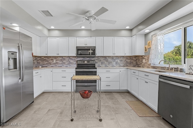 kitchen featuring ceiling fan, stainless steel appliances, decorative backsplash, and white cabinetry