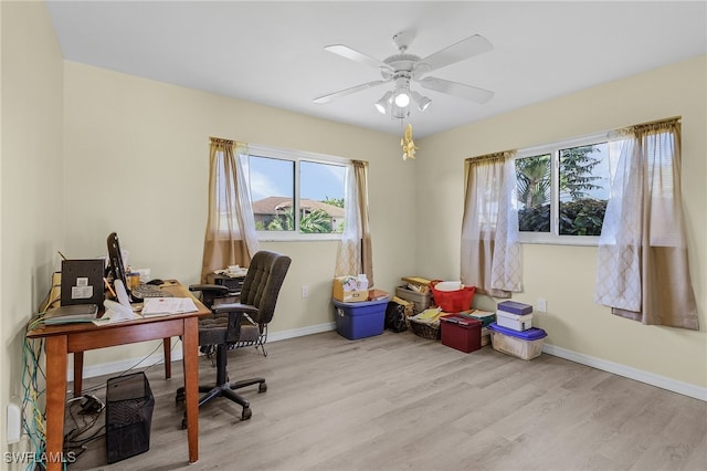 office with light hardwood / wood-style flooring and ceiling fan