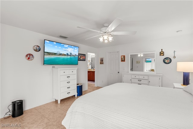 bedroom with light tile patterned flooring, ensuite bathroom, and ceiling fan