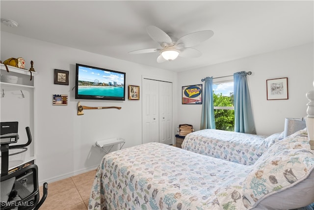 bedroom with a closet, light tile patterned floors, and ceiling fan