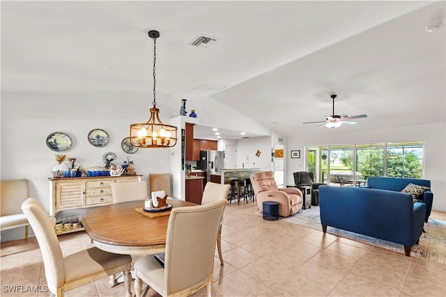 tiled dining room featuring lofted ceiling and ceiling fan with notable chandelier