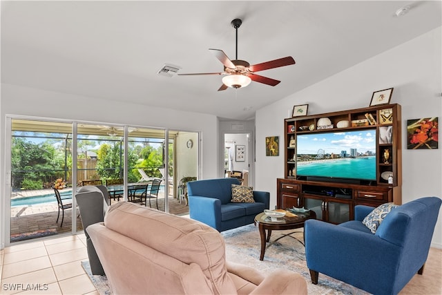 living room with ceiling fan, light tile patterned flooring, and vaulted ceiling