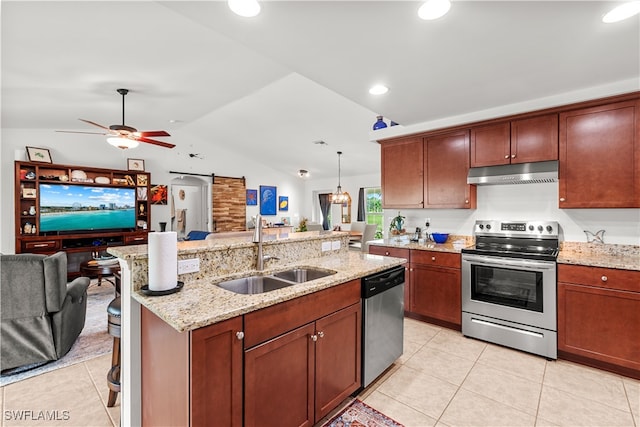 kitchen featuring sink, vaulted ceiling, a barn door, pendant lighting, and appliances with stainless steel finishes