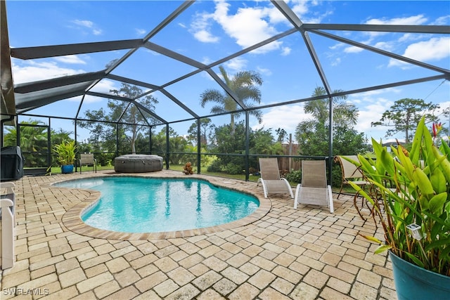 view of pool with a hot tub, a patio, and a lanai