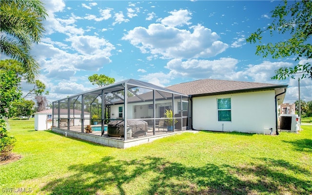 back of property with a pool, a yard, and a lanai