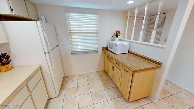 kitchen with white appliances and light tile patterned floors