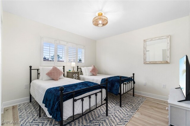 bedroom with baseboards and wood finished floors