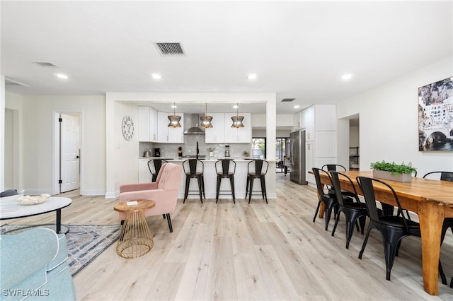 dining space featuring light wood-type flooring, visible vents, baseboards, and recessed lighting