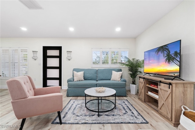 living area featuring light wood-type flooring, baseboards, and recessed lighting