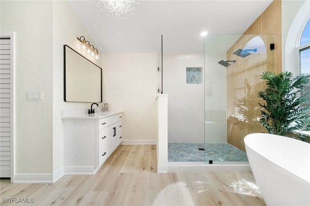 bathroom with a soaking tub, a walk in shower, wood finished floors, and vanity