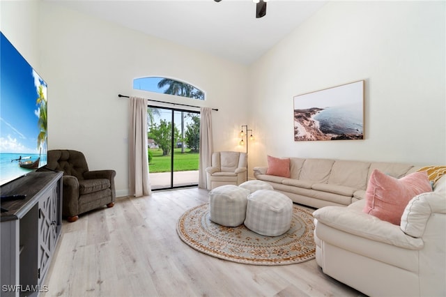 living area with ceiling fan, high vaulted ceiling, and wood finished floors