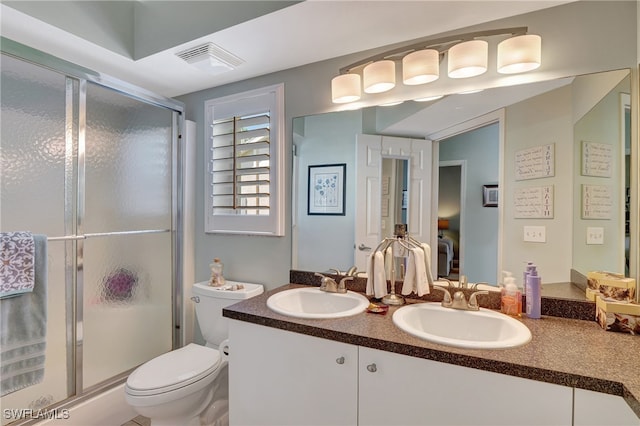 bathroom with vanity, toilet, and a shower with shower door