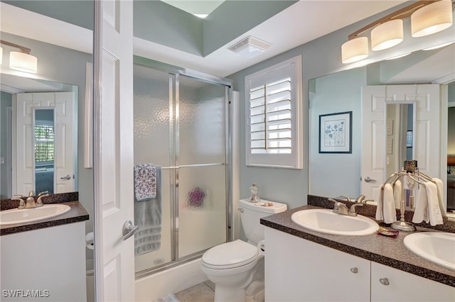 bathroom with vanity, toilet, tile patterned floors, and a shower with shower door