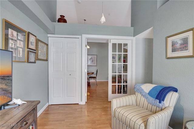 living area featuring high vaulted ceiling and light wood-type flooring