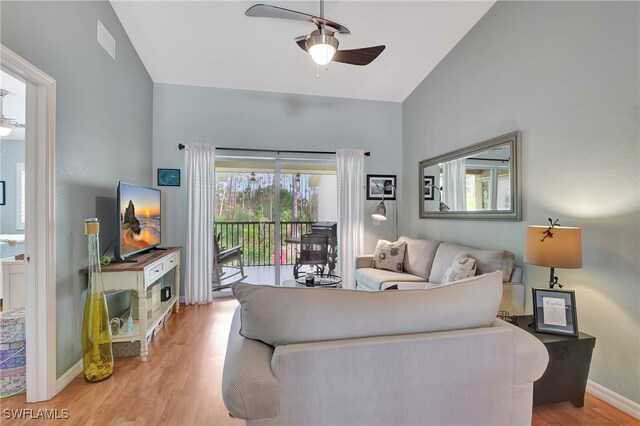 living room featuring lofted ceiling, ceiling fan, and light wood-type flooring