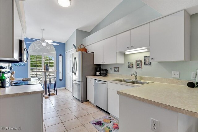 kitchen featuring white cabinetry, stainless steel appliances, sink, ceiling fan, and vaulted ceiling