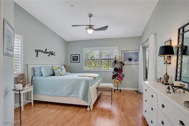 bedroom featuring light hardwood / wood-style flooring, ceiling fan, vaulted ceiling, and multiple windows