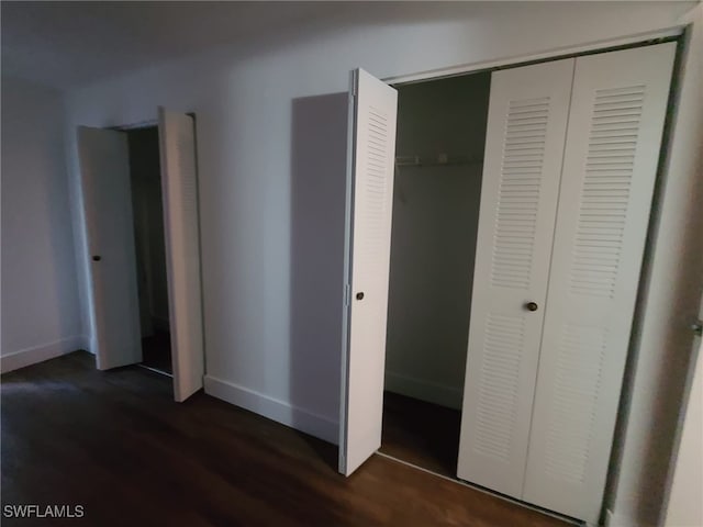 unfurnished bedroom with a closet and dark hardwood / wood-style floors