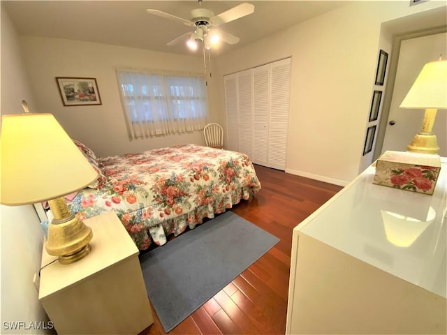 bedroom featuring dark wood-style floors, a closet, baseboards, and a ceiling fan