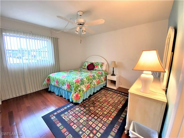 bedroom featuring wood finished floors, a ceiling fan, and baseboards