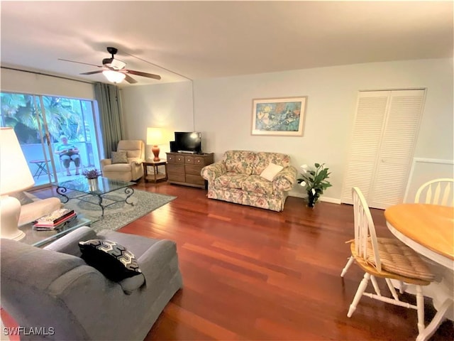 living area with ceiling fan, baseboards, and wood finished floors