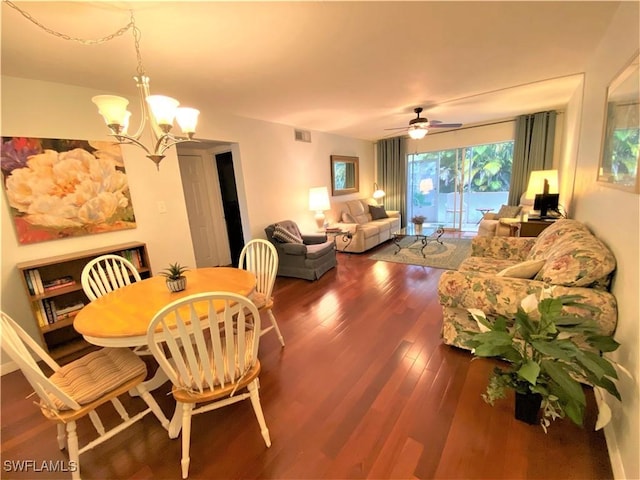 dining area with dark wood-style flooring, visible vents, and ceiling fan with notable chandelier