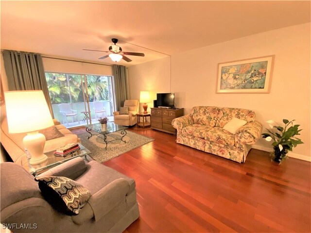 living room with ceiling fan and dark hardwood / wood-style floors