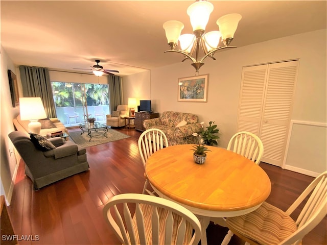 dining room featuring ceiling fan with notable chandelier and dark hardwood / wood-style flooring