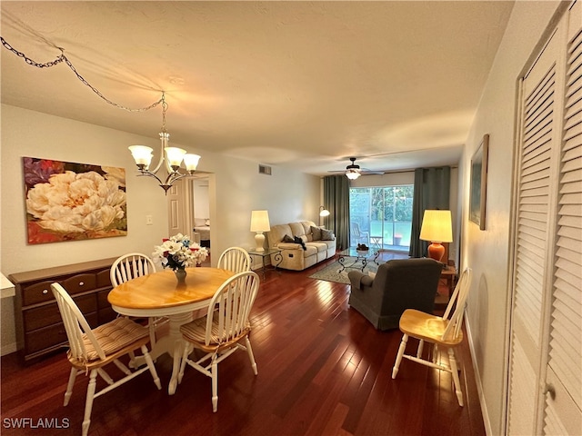 dining room featuring ceiling fan with notable chandelier and dark hardwood / wood-style flooring